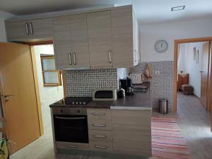 a kitchen with wooden cabinets and a stove top oven at Cozy Apartment in Drymades Village in Dhërmi +9 photos