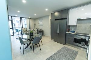 SummerstrandにあるBella Breeze Two Bedroom Apartmentのテーブルと椅子のあるキッチンとダイニングルーム