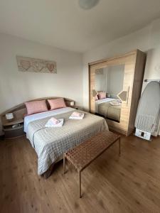 a bedroom with two beds and a bench in it at Appartement UNA La Bella 3* in Bihać