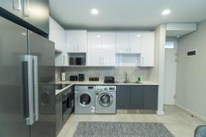 SummerstrandにあるBella Breeze Two Bedroom Apartmentのキッチン(白いキャビネット、洗濯機、乾燥機付)