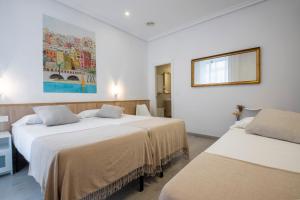 Una habitación con dos camas y un cuadro en la pared. en Pensión Donostiarra, en San Sebastián