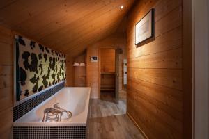 a bath tub in a room with wooden walls at Chalet La Souris, chaleureux avec vue panoramique in Gérardmer