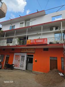 a hotel with an orange and white building at Midnight Black By BnBGuys in Orchha