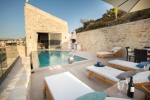 a patio with a swimming pool and a villa at Villa Celine in Kamilari
