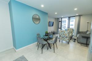 SummerstrandにあるBella Breeze Two Bedroom Apartmentの青い壁のリビングルーム(テーブル、椅子付)
