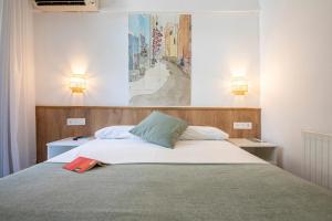 Un dormitorio con una cama con una carpeta roja. en Pensión Donostiarra, en San Sebastián