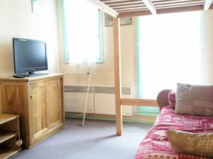 a bedroom with a bed and a television on a stand at Studio confortable avec balcon et casier à skis - FR-1-557-111 in Les Adrets +3 photos