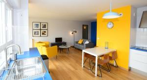 a living room with a table and a yellow wall at Appart' Parc in Villeurbanne