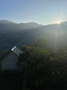 a barn in the middle of a valley with the sun shining at Cool Mount Resort in Ella