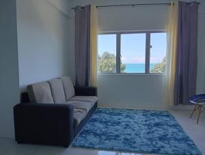 a living room with a couch and a large window at EM Camar Seaview Homestay at Sutra Villa2 in Kuantan