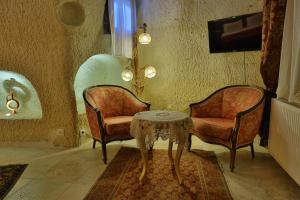 ウルギュップにあるDemisos Caves Hotelの部屋に椅子2脚とテーブル1台