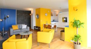 a living room with yellow chairs and a table at Appart' Parc in Villeurbanne