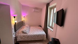 a small bedroom with a bed and a flat screen tv at Amly's Room in Maratea