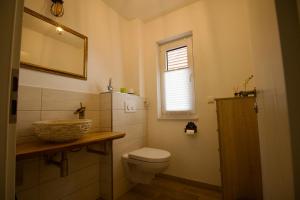a bathroom with a toilet and a sink and a window at Ferienhaus Plattenberg in Bad Oeynhausen +64 photos