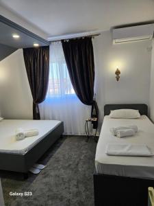 a bedroom with two beds and a window at Vila Massimo in Eforie Nord