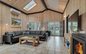 a living room with a couch and a fireplace at Pet Friendly Home In Oksbøl With Sauna in Oksbøl