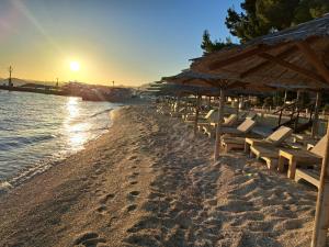 a beach with chairs and umbrellas and the ocean at Villa Nikolina in Srinjine