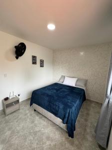 a bedroom with a bed with a blue blanket at Casa San Miguel 101 in Medellín