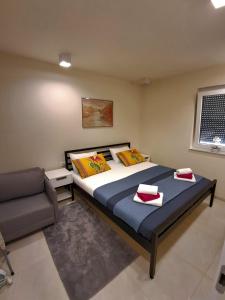 a bedroom with a large bed and a couch at Apartmani Datea in Grebaštica +42 photos