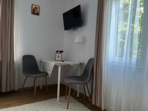 a room with a table and two chairs and a television at Pridvorul lui Viorel in Proviţa de Sus