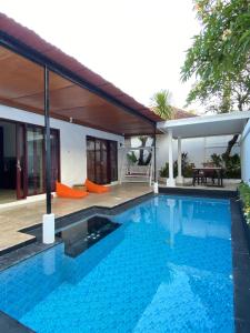 a swimming pool in front of a house at One Bedroom Private Pool Classic Villa in Kuta