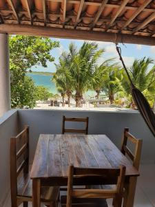 a wooden table with chairs and a view of the beach at Jangaloa in Jijoca de Jericoacoara