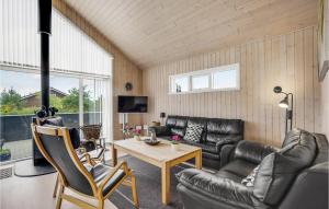 a living room with leather furniture and a table at Holiday Home Jordbærvej Tarm Iv in Hemmet