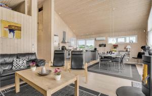 a living room with a couch and a table at Holiday Home Jordbærvej Tarm Iv in Hemmet