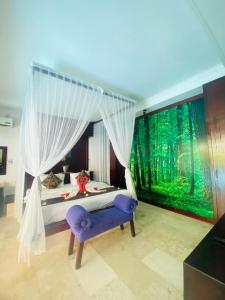 a bedroom with a canopy bed and a purple chair at One Bedroom Private Pool Classic Villa in Kuta