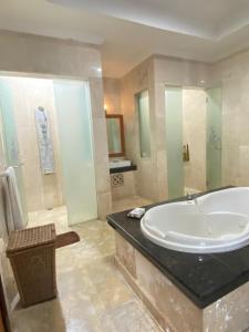 a large bathroom with a tub and a shower at One Bedroom Private Pool Classic Villa in Kuta