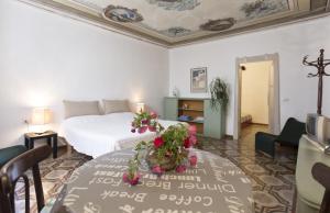アルゲーロにあるCasa Margheritaのベッド1台、テーブル(花付)
