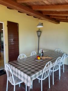 a dining room table with white chairs and a checkered table cloth at Casa Rosetta in Postuman +20 photos