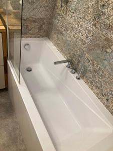 a white bath tub in a bathroom with a shower at Nowoczesne mieszkanie Yellow in Pogórze +23 photos