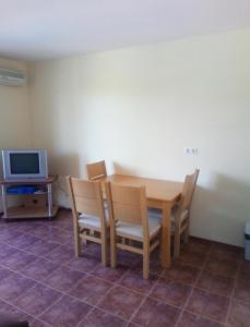 ein Esszimmer mit Tisch und Stühlen und einem Fernseher in der Unterkunft Spacious Family Fully Furnished 2 Rooms Apartment in Kavarna Apart Hotel in Kawarna + 14 Fotos