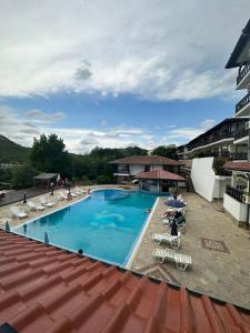 ein großer Swimmingpool mit Liegen und Sonnenschirmen in der Unterkunft Spacious Family Fully Furnished 2 Rooms Apartment in Kavarna Apart Hotel in Kawarna