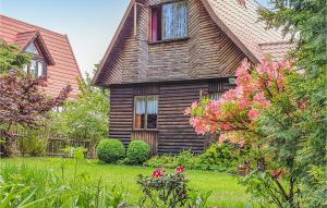 una casa de madera con flores en el patio en Holiday Home Gietrzwald Sila, en Kręsk