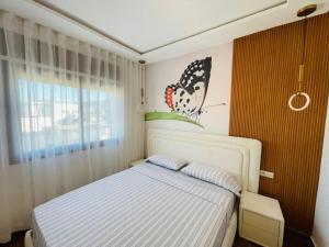 una camera da letto con un letto con una farfalla sul muro di Little Gem a Martil