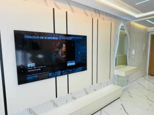 una stanza con una TV a schermo piatto su una parete di Little Gem a Martil