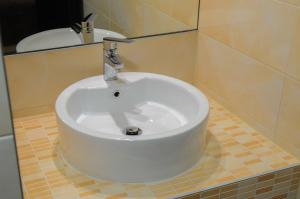 a white sink in a bathroom with a mirror at Božikovina Beach Rooms in Podstrana