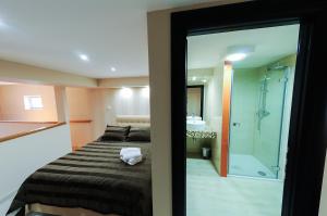 a bedroom with a bed and a glass shower at Božikovina Beach Rooms in Podstrana
