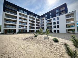 a large building with a beach in front of it at Horizon Park Lux Boszkowo in Boszkowo-Letnisko
