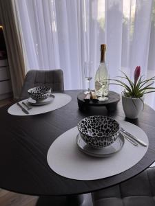 a table with two plates and a bottle of wine at Horizon Park Lux Boszkowo in Boszkowo-Letnisko +7 photos