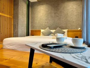 a table with two cups on top of a bed at Mira Naiharn, Minimalist Design & Mountain View at Relife Windy in Rawai Beach +38 photos