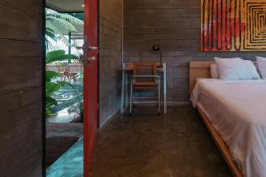 a bedroom with a bed and a table with a chair at Huni Homestay Tembi in Bantul