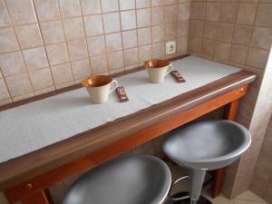 two cups sitting on a counter with two stools at Apartment Ana in Zadar