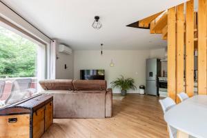 a living room with a couch and a table at LE PANORAMIQUE gîte au calme avec jacuzzi in Soultzbach-les-Bains