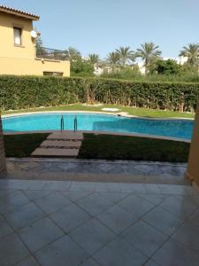 two people standing in front of a swimming pool at Villa Marassi in El Alamein