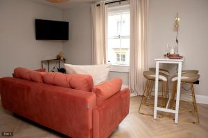 a living room with a red couch and a table at 1 Bed Apartments - Central Bath in Bath