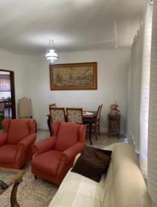 a living room with a couch and chairs and a table at Casa Residencial, sobrado in Serra Negra