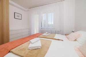 チジチにあるApartments Star by the seaのタオルが敷かれた白い部屋にベッドが2つある